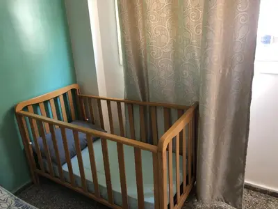 a crib in a room with a curtain at Familly Apartement Agdal Rabat centre in Rabat