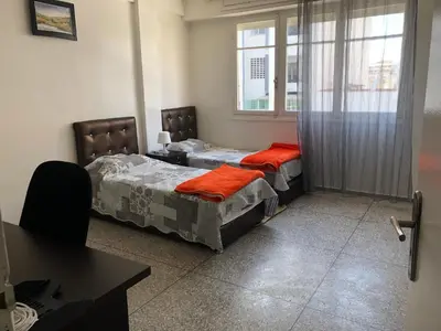 two beds in a room with a window at Familly Apartement Agdal Rabat centre in Rabat