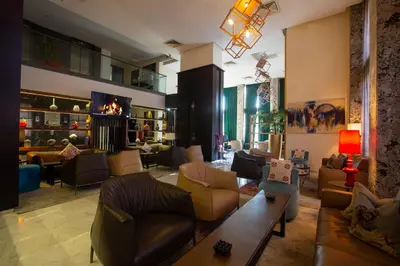 a living room with couches and chairs and a fireplace at Hôtel du Golf Mohammedia in Mohammedia