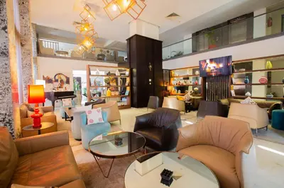 a lobby with couches and tables and a piano at Hôtel du Golf Mohammedia in Mohammedia