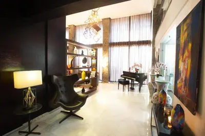 a living room with a chair and a piano at Hôtel du Golf Mohammedia in Mohammedia