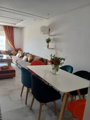 a living room with a white table and chairs at residance a 100 m de la mer in El Harhoura