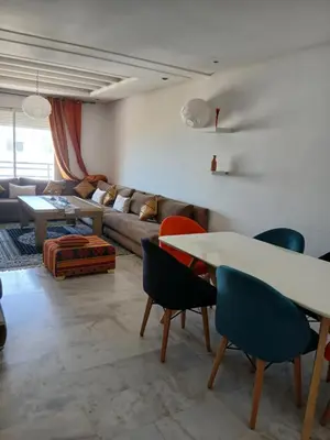 a living room with a couch and a table and chairs at residance a 100 m de la mer in El Harhoura