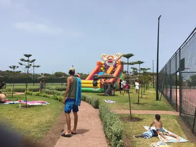 a group of people standing in front of a playground at Savannah Beach D11 in Sidi Rahal