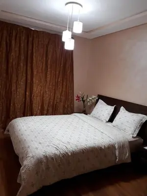 a bedroom with a large bed with white sheets and a window at Nouaceur Garden Comfort and Serenity Casa Airport in Nouaseur