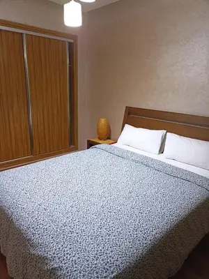 a bedroom with a bed with a blue comforter at Nouaceur Garden Comfort and Serenity Casa Airport in Nouaseur