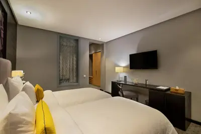a bedroom with two beds and a desk and a television at ODYSSEE Boutique Hotel Casablanca in Casablanca