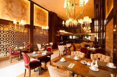 a restaurant with wooden tables and chairs and chandeliers at Suite Hotel Casa Diamond in Casablanca