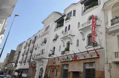 a white building with a sign on the side of it at Hôtel Transatlantique in Casablanca