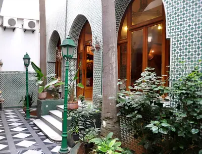 a green pole in front of a building with plants at Hôtel Transatlantique in Casablanca