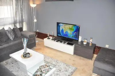 a living room with a flat screen tv on a table at Elegant Apartment with Balcony in Val Fleuri, Maarif Casablanca, Perfect for Family & Corporate Stays in Casablanca