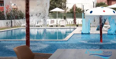 a swimming pool with a fountain in the middle at L'escale Suites Résidence Hôtelière By 7AV HOTELS in Mohammedia