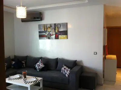 a living room with a couch and a table at Appartement Cosy - Corniche plage Mohammedia in Mohammedia