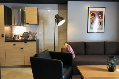 a living room with a couch and a kitchen at Suite Loc Suite & Spa in Casablanca