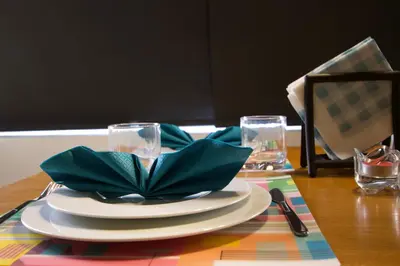 a table with a plate with a green napkin on it at Suite Loc Suite & Spa in Casablanca