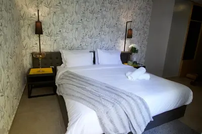 a bedroom with a large bed with white sheets at Suite Loc Suite & Spa in Casablanca