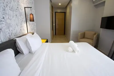 a bedroom with a white bed with a towel on it at Suite Loc Suite & Spa in Casablanca