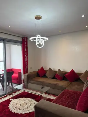 a living room with a couch and a ceiling fan at Appartement Casa-marina au 10ème étage in Casablanca