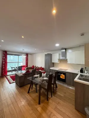 a kitchen and living room with a table and a couch at Appartement Casa-marina au 10ème étage in Casablanca