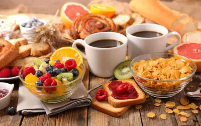 a table with bowls of fruit and toast and cups of coffee at Appartement Casa-marina au 10ème étage in Casablanca