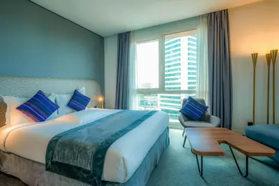 a bedroom with a large bed and a large window at Kyriad Residence Casablanca in Casablanca