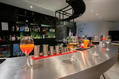 a bar with four wine glasses on a counter at Kyriad Residence Casablanca in Casablanca