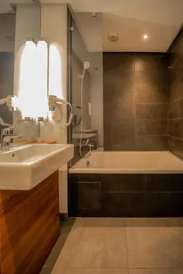 a bathroom with a sink and a bath tub at Campanile Casablanca Centre Ville in Casablanca
