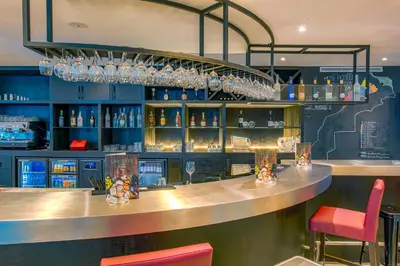 a bar in a restaurant with red chairs and glasses at Campanile Casablanca Centre Ville in Casablanca