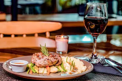 a plate of food on a table with a glass of wine at Campanile Casablanca Centre Ville in Casablanca