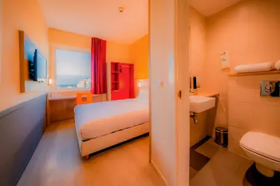 a bedroom with a bed and a sink and a toilet at Premiere Classe Casablanca Centre Ville in Casablanca