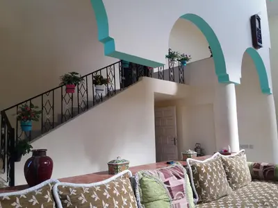a living room with a couch and a staircase at villa waresa in Derroua