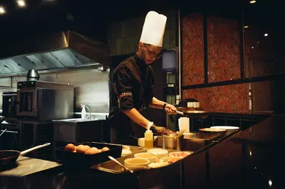 a man in a chefs hat preparing food in a kitchen at ONOMO Hotel Casablanca City Center in Casablanca