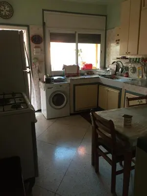 a kitchen with a washing machine and a table at Property in a quiet area close to the train station and town in Casablanca