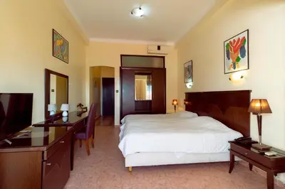 a bedroom with a bed and a desk and a television at Hotel Bellerive in Casablanca