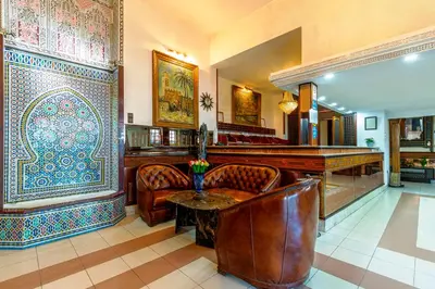 a bar with leather chairs and a table in a room at Hotel Bellerive in Casablanca