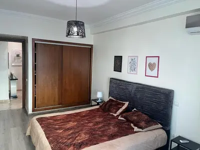 a bedroom with a large bed with a black headboard at home zen in Rabat