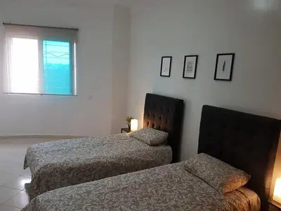 a hotel room with two beds and a window at home zen in Rabat