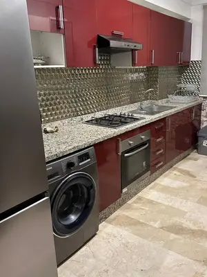 a kitchen with red cabinets and a washing machine at Appartement Casablanca vue sur mer in Casablanca