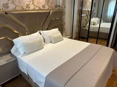 a bed with white sheets and pillows and a mirror at Appartement Casablanca vue sur mer in Casablanca
