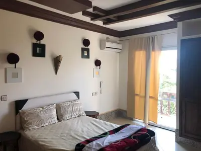 a bedroom with a bed and a large window at reda land in O Ben Slimane