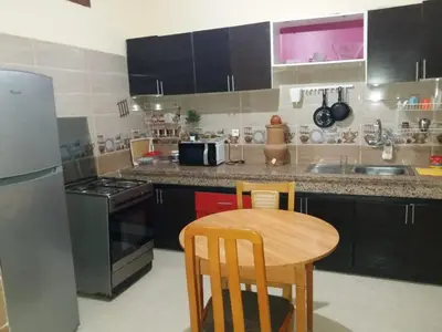 a small kitchen with a table and a refrigerator at Mohammed V Airport HOME in Deroua