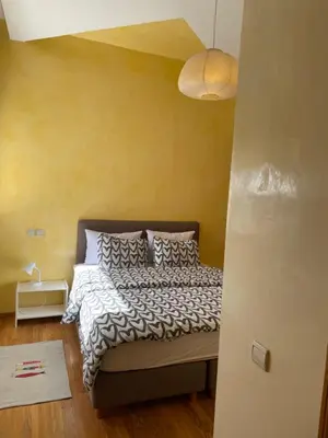 a bedroom with a bed and a yellow wall at Airport to Comme à la maison 1 in Nouaseur