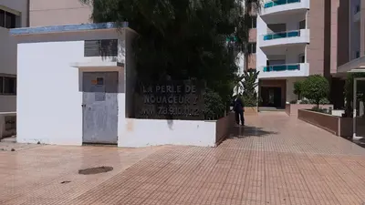 a sign on the side of a building on a street at Airport to Comme à la maison 1 in Nouaseur