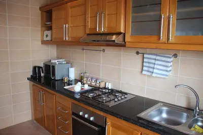 a kitchen with a stove top oven next to a sink at Airport to Comme à la maison 1 in Nouaseur