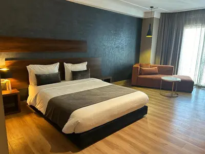 a bedroom with a large bed and a chair at Yto boutique Hotel in Casablanca