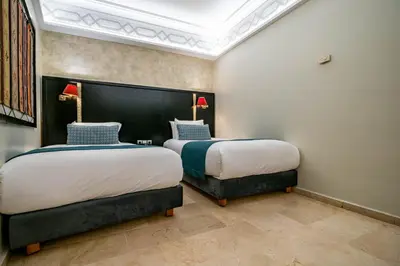two beds in a hotel room with two bedsskirtspectspectssenalsenal at Diwan Casablanca Hotel & Spa in Casablanca