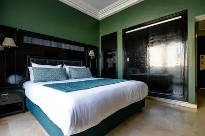 a bedroom with a large bed and a green wall at Diwan Casablanca Hotel & Spa in Casablanca