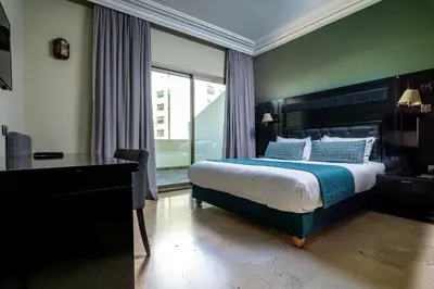 a bedroom with a bed and a desk and a window at Diwan Casablanca Hotel & Spa in Casablanca