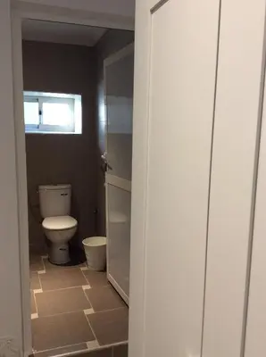 a bathroom with a toilet and a window at Palm Grove Farm in Tit Mellil