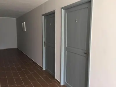 an empty hallway with two doors and a tile floor at Palm Grove Farm in Tit Mellil
